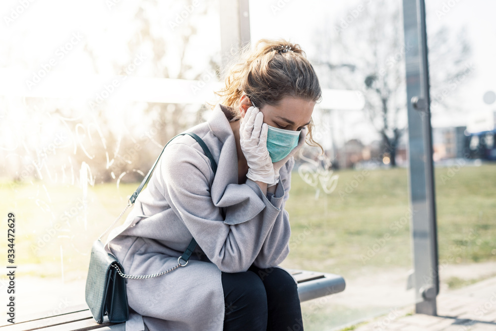 Woman wearing surgical protective mask having a headache in a public transportation Woman wearing surgical protective mask having a headache in a public transportation
