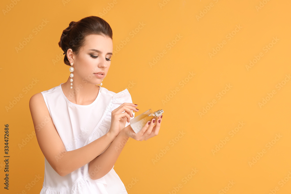 Beautiful young woman with perfume on color background Beautiful young woman with perfume on color background