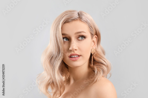 Young blonde with beautiful hair on light background