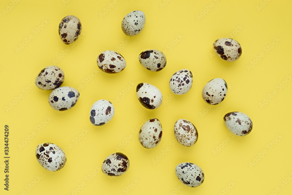 Chaotic pattern of easter quail eggs on a yellow background. Happy easter banner