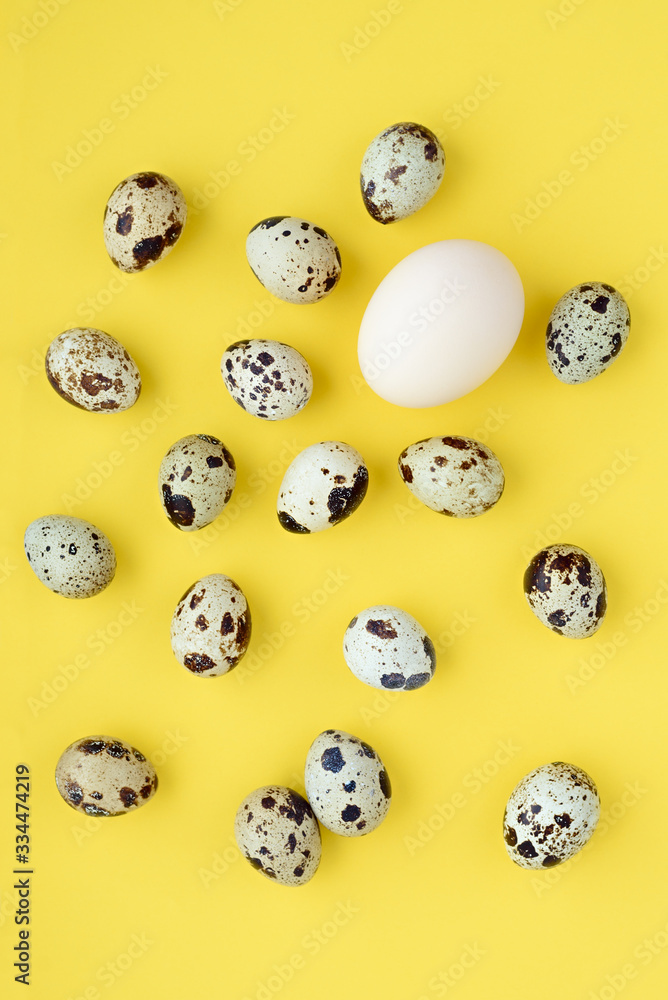 Chaotic pattern of easter eggs on a yellow background. Happy easter banner. One large white egg among small quail eggs