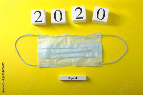 Wallpaper Mural Medical blue mask on a yellow background, wooden calendar, epidemic Torontodigital.ca