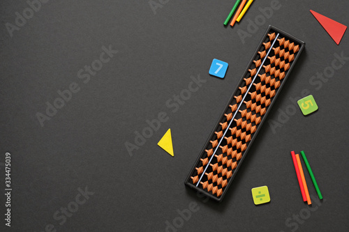 Abacus with numbers on black background - mental mathematics, arithmetic, math concept.