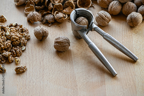 walnuts and nutcracker on wooden background
