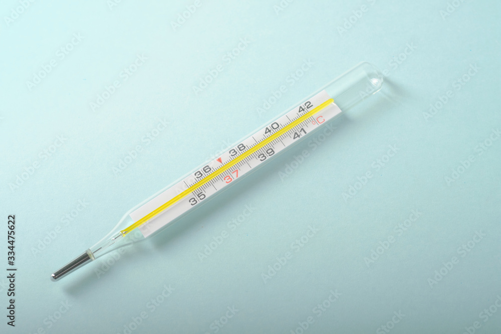 Glass thermometer for measuring temperature on a blue background Glass thermometer for measuring temperature on a blue background