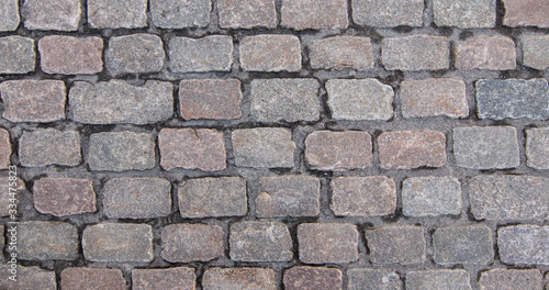 Old cobblestone pavement. Overhead view of grey rectangular stones. Background texture, close-up.