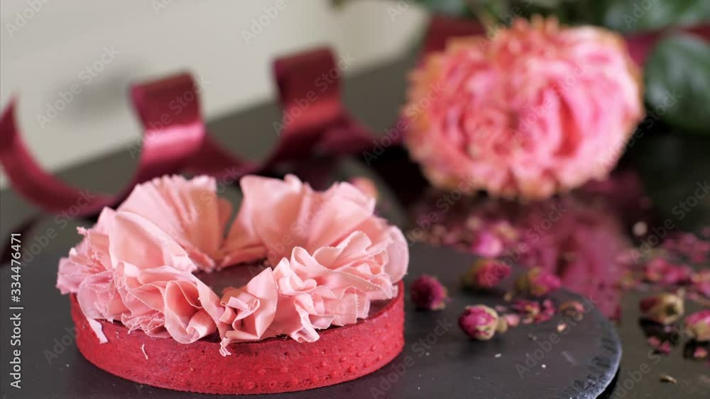 Professional confectioner is making a dessert with petals from pink chocolate for Valentine's Day Professional confectioner is making a dessert with petals from pink chocolate for Valentine's Day