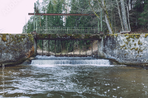 City Vaive, Latvia. River with water and locks, forest and trees. photo