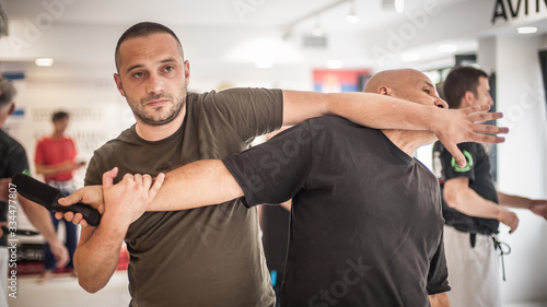 Fotografie Two students train knife disarm techniques on martial arts seminar