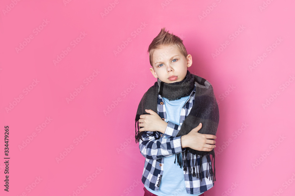 Baby, boy 8-9 years old on pink background sick with coronavirus upset, holds a thermometer Baby, boy 8-9 years old on pink background sick with coronavirus upset, holds a thermometer