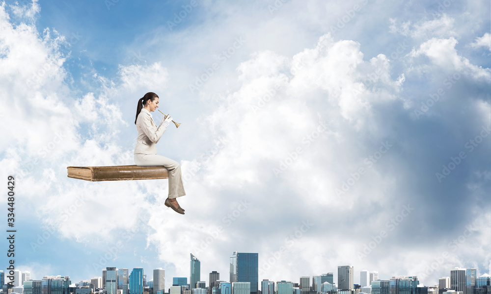 Elegant woman in business suit sitting on book Elegant woman in business suit sitting on book