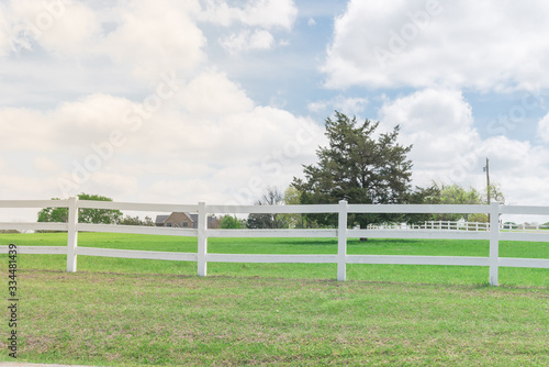 Shallow DOF long white fence with defocused farm house ranch in background in Ennis, Texas, USA