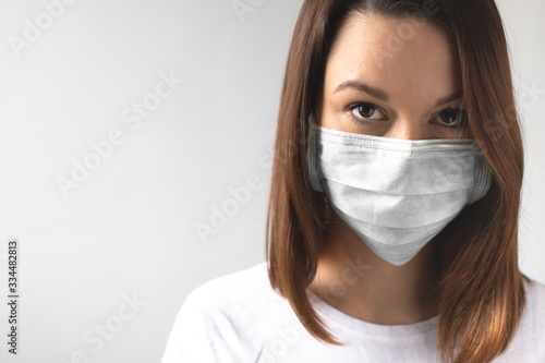 Coronavirus concept. Girl wearing a protective medical mask. Protect your health. Stop the virus and pandemic covid-19. Light gray background