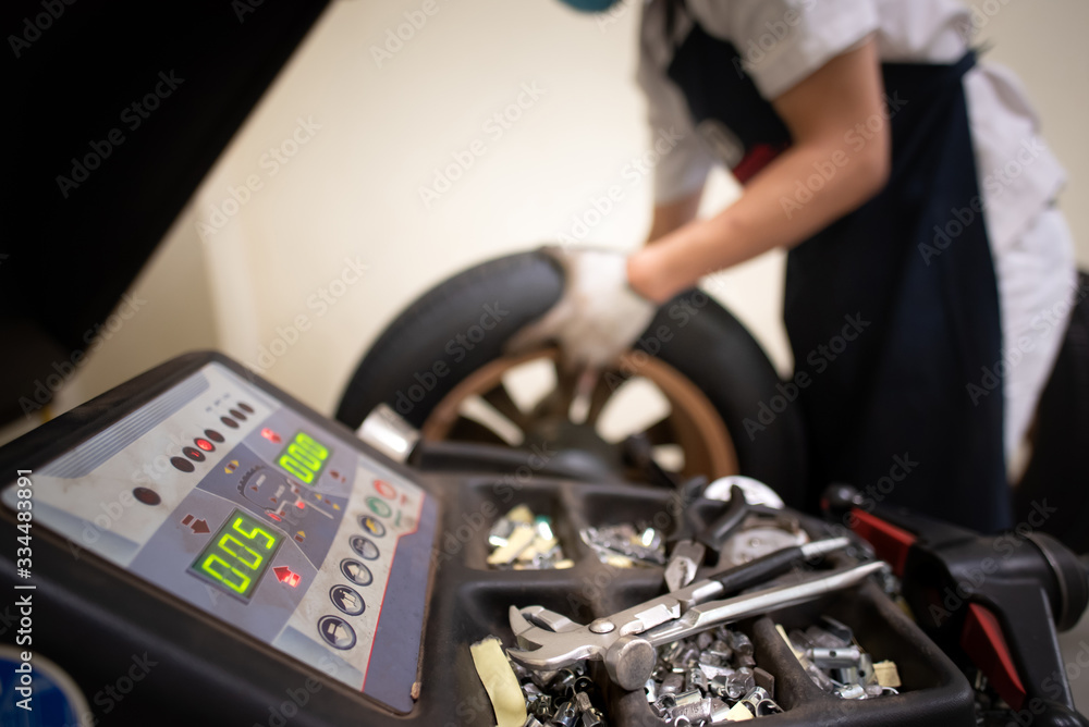 Service technicians are changing tires using a balancing machine with maintenance services.