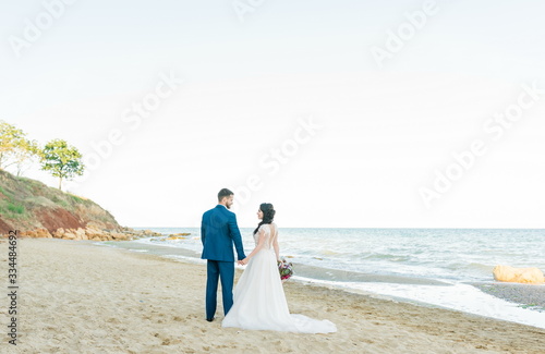 Bride and groom at wedding Day on the beach near the sea. Smiling bride and groom. Young couple in love hugging near sea shore
