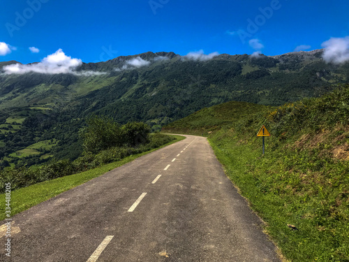 carretera asturiana del puerto angliru con las montañas de un verde precioso y cielo azul despejado