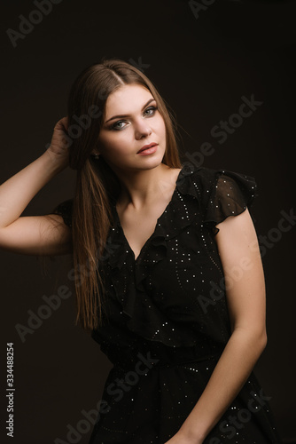 Fashion studio portrait of young beautiful woman on black background
