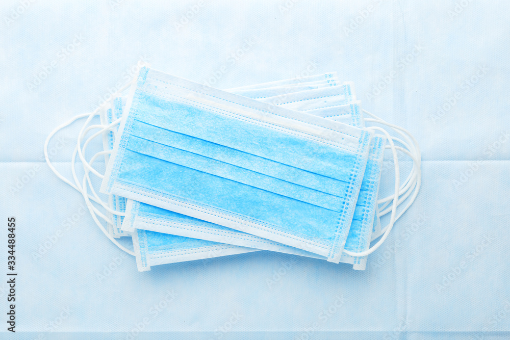 Medical mask, Medical protective masks on blue background. Coronovirus Covid-19 protective. Disposable surgical face mask cover the mouth and nose. Healthcare and medical concept.Stop Sars-cov-2 virus Medical mask, Medical protective masks on blue background. Coronovirus Covid-19 protective. Disposable surgical face mask cover the mouth and nose. Healthcare and medical concept.Stop Sars-cov-2 virus