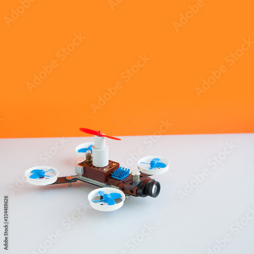 Fotografie, Tablou Drone multicopter with camera, orange white background