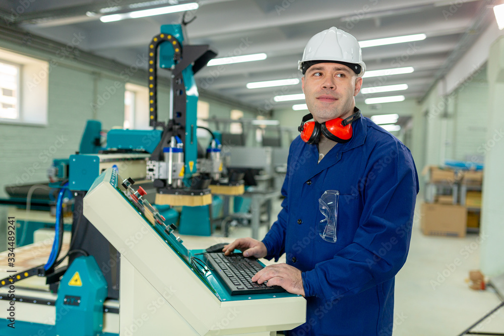 Worker in the Hard Hat Modern Factory CNC machine operator . Successful, Handsome Man in Modern Industrial Environment.Emotions, Copy Space Worker in the Hard Hat Modern Factory CNC machine operator . Successful, Handsome Man in Modern Industrial Environment.Emotions, Copy Space