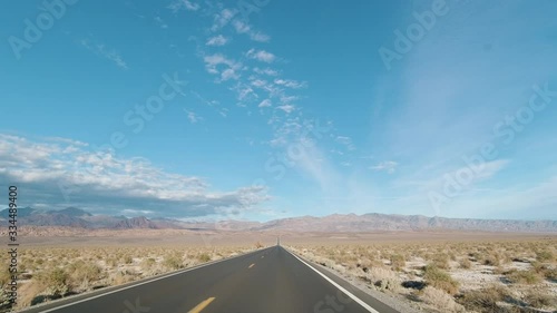 Car Driving on Road to Badwater Basin on Sunny Day. Death Valley National Park. California, USA. 