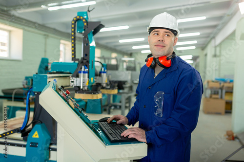 Worker in the Hard Hat Modern Factory CNC machine operator . Successful, Handsome Man in Modern Industrial Environment.Emotions, Copy Space