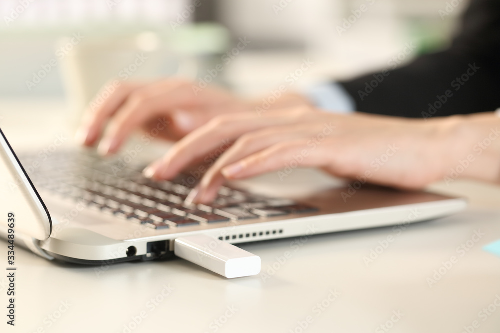 Executive hands using laptop with plugged pendrive Executive hands using laptop with plugged pendrive