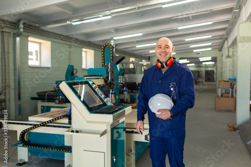 Worker in the Hard Hat Modern Factory CNC machine operator . Successful, Handsome Man in Modern Industrial Environment.Emotions, Copy Space