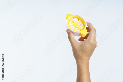 Hand holding plastic boiled egg slicer