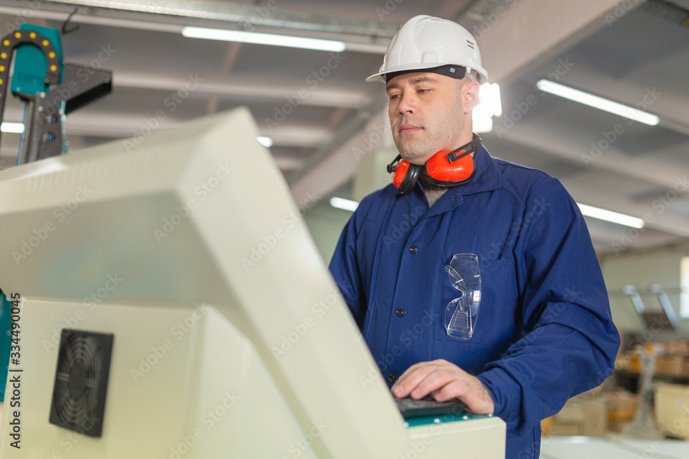 Worker in the Hard Hat Modern Factory CNC machine operator . Successful, Handsome Man in Modern Industrial Environment.Emotions, Copy Space