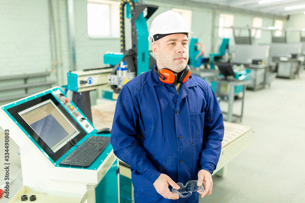 Worker in the Hard Hat Modern Factory CNC machine operator . Successful, Handsome Man in Modern Industrial Environment.Emotions, Copy Space Worker in the Hard Hat Modern Factory CNC machine operator . Successful, Handsome Man in Modern Industrial Environment.Emotions, Copy Space