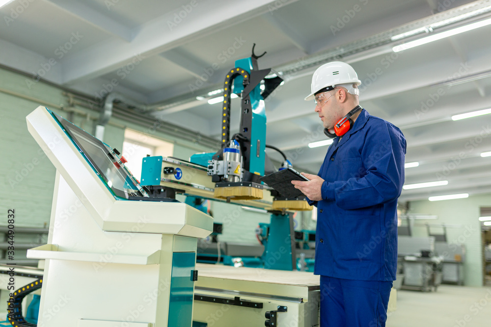 Naklejka premium Worker in the Hard Hat Modern Factory CNC machine operator . Successful, Handsome Man in Modern Industrial Environment.Emotions, Copy Space 
