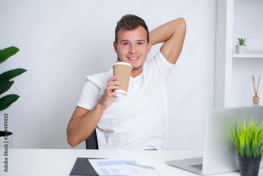 Successful businessman in white shirt is working in the office of the company on a laptop Successful businessman in white shirt is working in the office of the company on a laptop