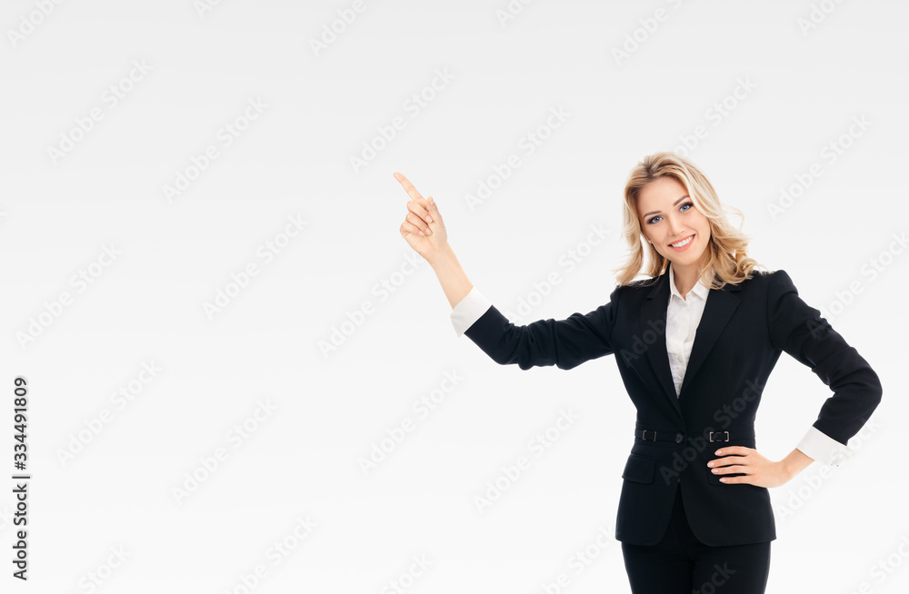 Confident businesswoman, showing something or copy space area for slogan or text, over grey background. Caucasian blond model in business presentation or sales ad concept. Confident businesswoman, showing something or copy space area for slogan or text, over grey background. Caucasian blond model in business presentation or sales ad concept.