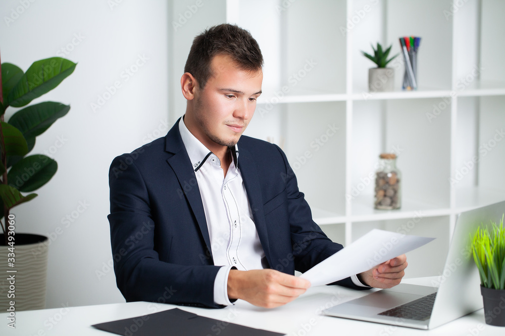 Solid businessman in a jacket works with documents in the office of the company