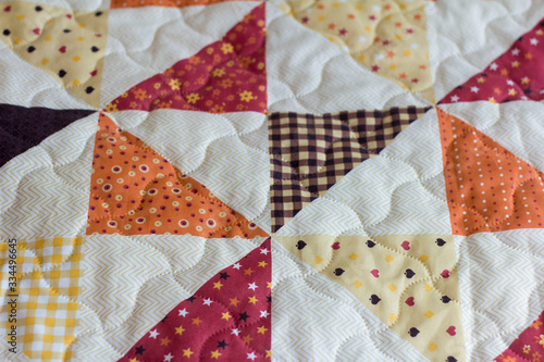 A patchwork quilt or bedspread.A fragment of a patchwork quilt as a background. Colored patchwork quilt. Colored blanket.