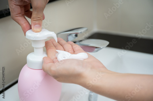 Hand liquid soap pumping bottle on the wash basin in toilet. Hygiene and healthcare awareness in everyday lifestyle concept.