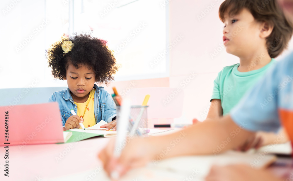 Portrait of African girl drawing at the desk in the preschool. Portrait of African girl drawing at the desk in the preschool.