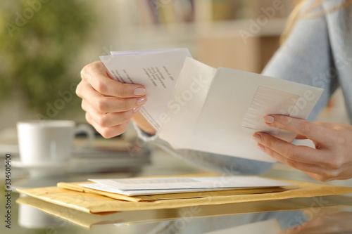 Girl hands opening an envelope on a desk at home photo