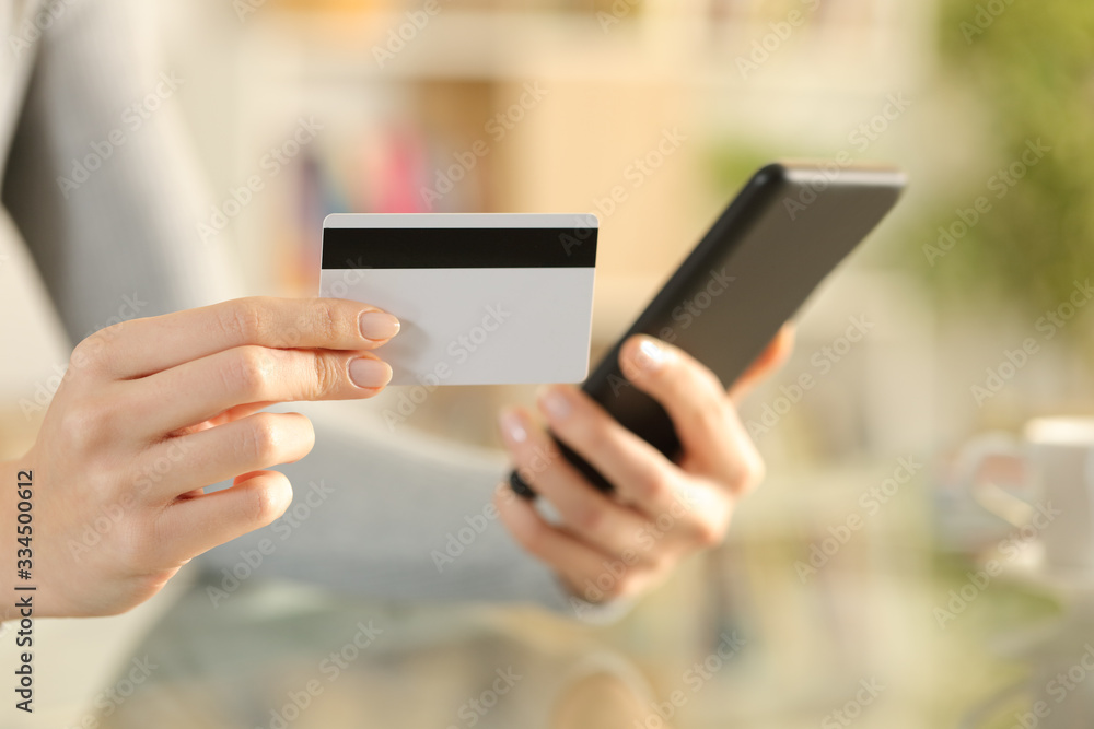 Woman hands paying with credit card on phone Woman hands paying with credit card on phone