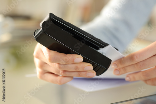 Woman hands stapling papers on a desk at home