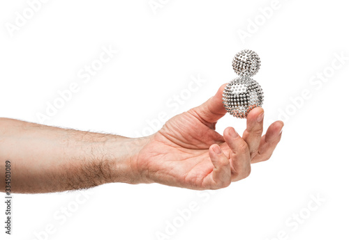 Male hands hold silver balls similar to a virus. The background is isolated.