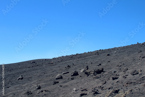 Black lava ash field under blue skies (Volcano Etna, Sicily, Italy)