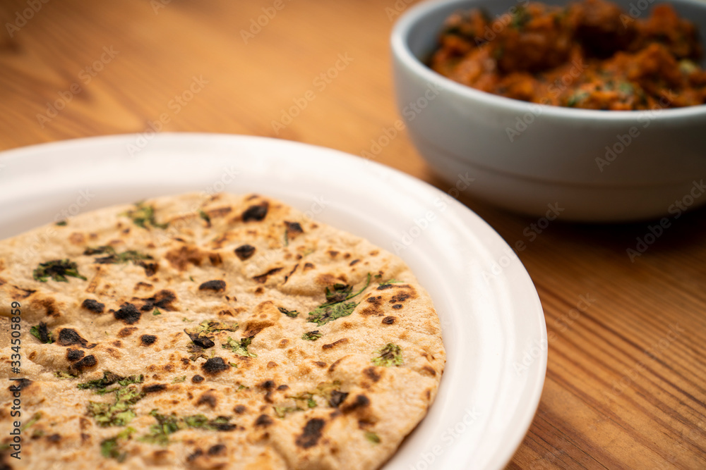 Potato curry with chapatti (roti) placed on wooden table. stock photo Potato curry with chapatti (roti) placed on wooden table. stock photo