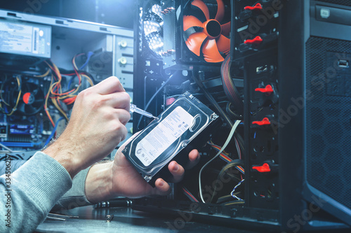 Technician repairing a computer, the process of replacing components on the motherboard. The technician hold the screwdriver for repairing PC. The concept of computer hardware, repairing, upgrade