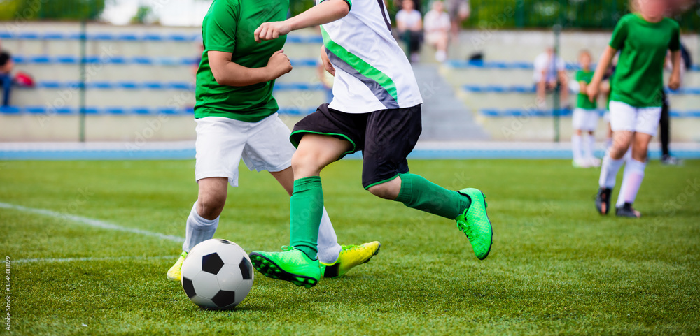 Running Football Soccer Players. Sports Competition Between Youth Soccer Teams. Young Boys in Hard Duel Playing Soccer Game. Junior Footballer Kicking Soccer Ball Running Football Soccer Players. Sports Competition Between Youth Soccer Teams. Young Boys in Hard Duel Playing Soccer Game. Junior Footballer Kicking Soccer Ball