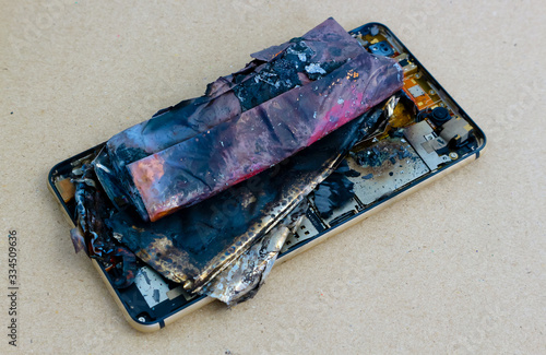 smartphone battery explodes on a brown paper background.