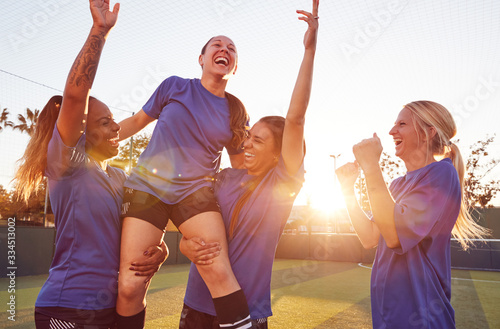 Womens Football Team Celebrating Winning Soccer Match Lifting Player Onto Shoulders