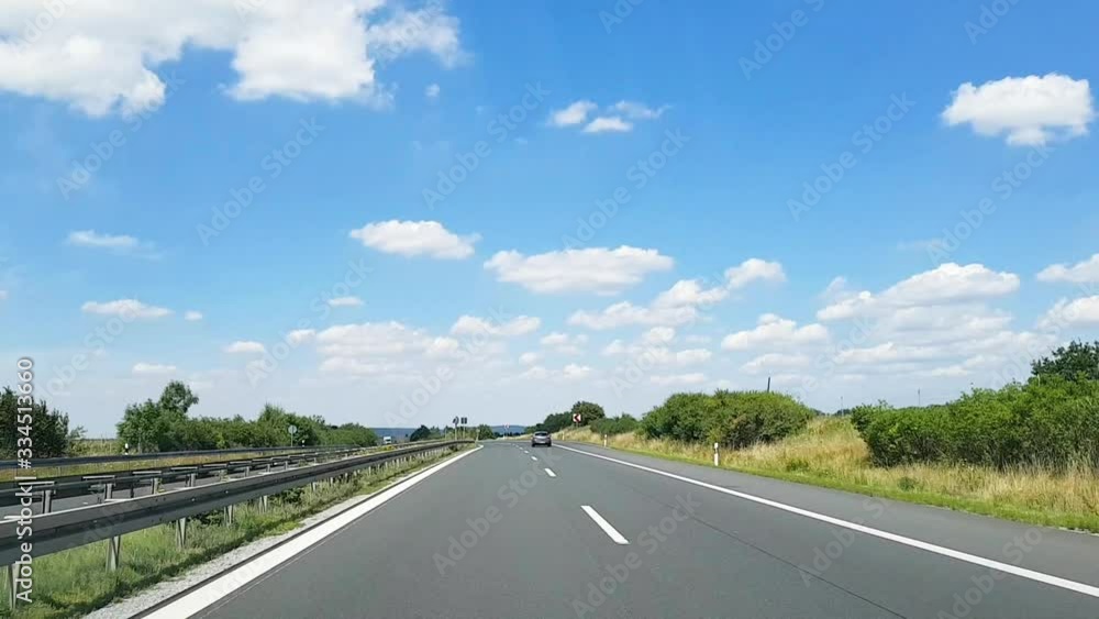 Germany. Frankfurt am Main. 16.07.2018. A shot through the windshield of a car that rides on the autobahn in Germany against a blue sky and field. Germany. Frankfurt am Main. 16.07.2018. A shot through the windshield of a car that rides on the autobahn in Germany against a blue sky and field.