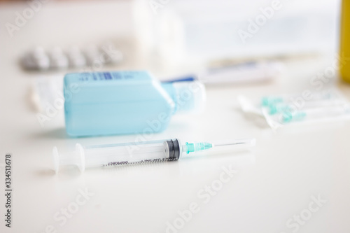 Medical supplies kit for health emergencies, consisting of thermometer, bandages, analgesics, antiseptics, serum, hand sanitizer, needles and syringe, on white background, selective focus